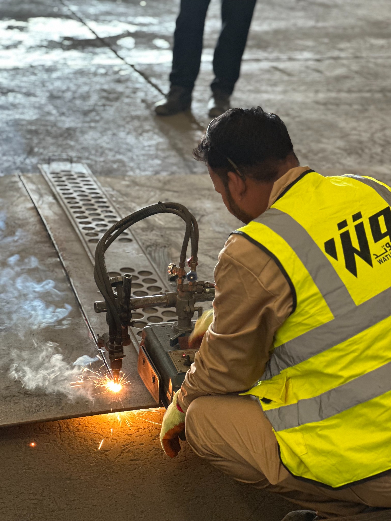 Worker using a cutting torch on steel in the workshop