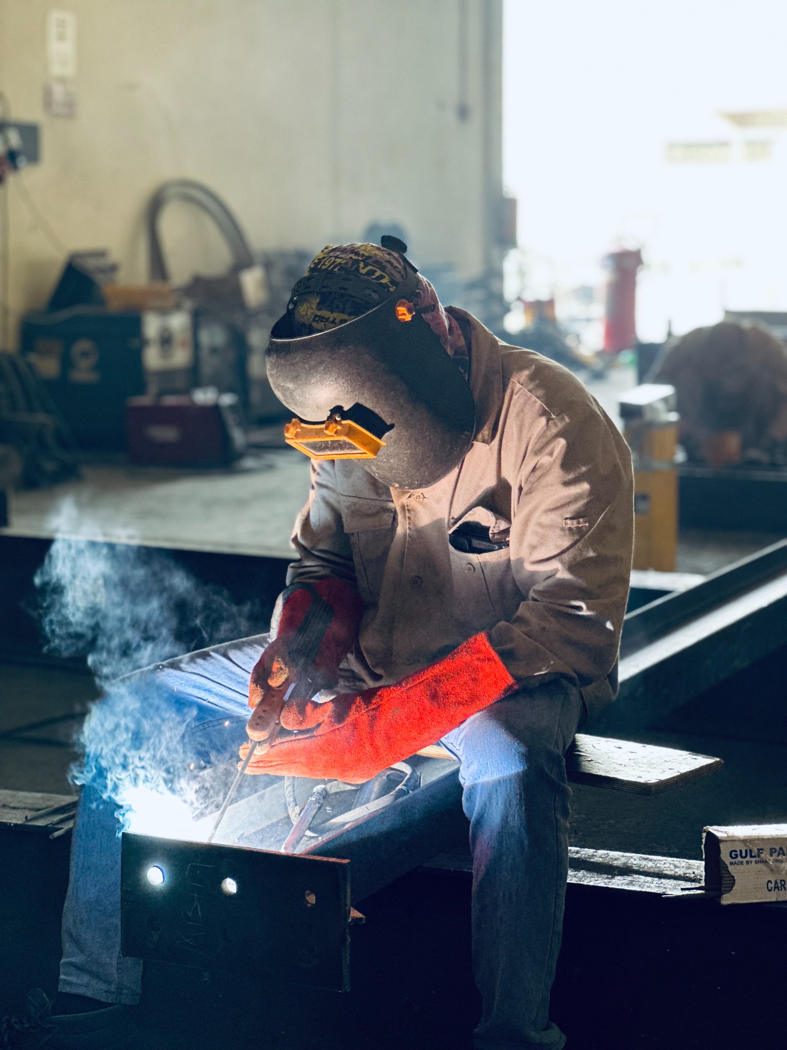Welder joining a steel component in the workshop