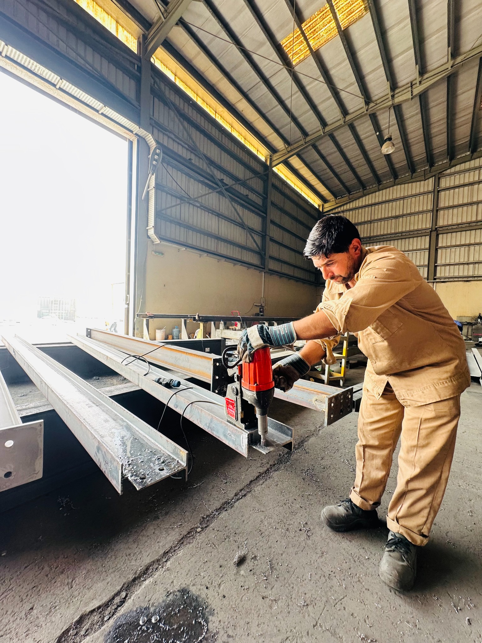 Worker preparing the surface of a steel component