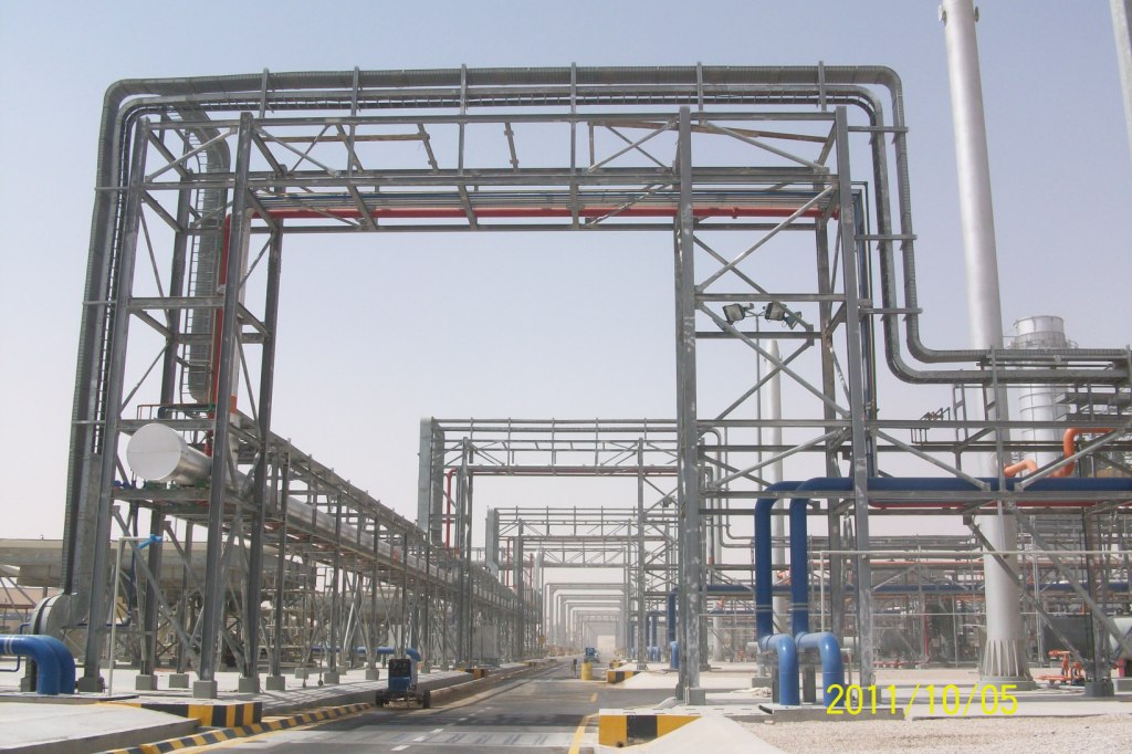 Overhead steel frames carrying industrial services across a roadway