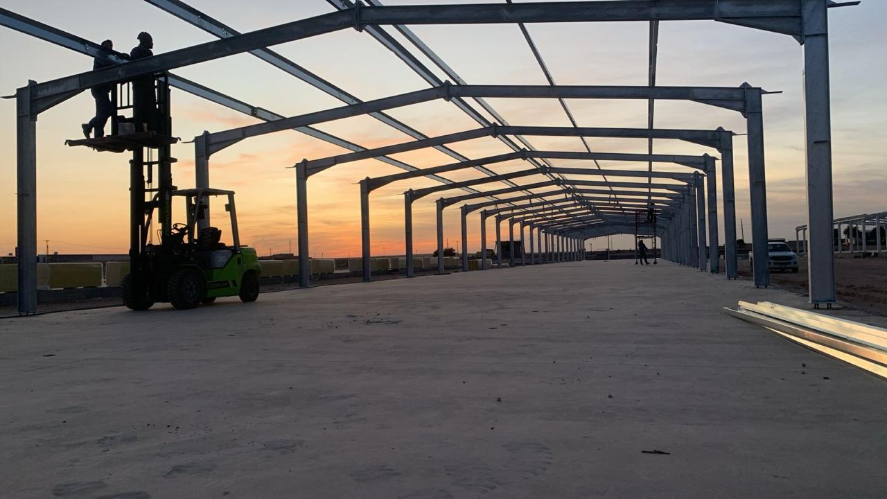 Rows of steel portal frames at a construction site